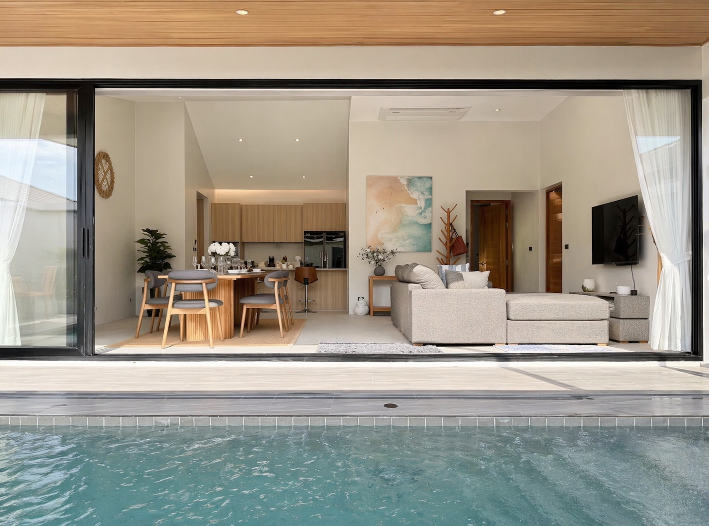 Villa Belplaya's private pool flowing into the open-plan living room